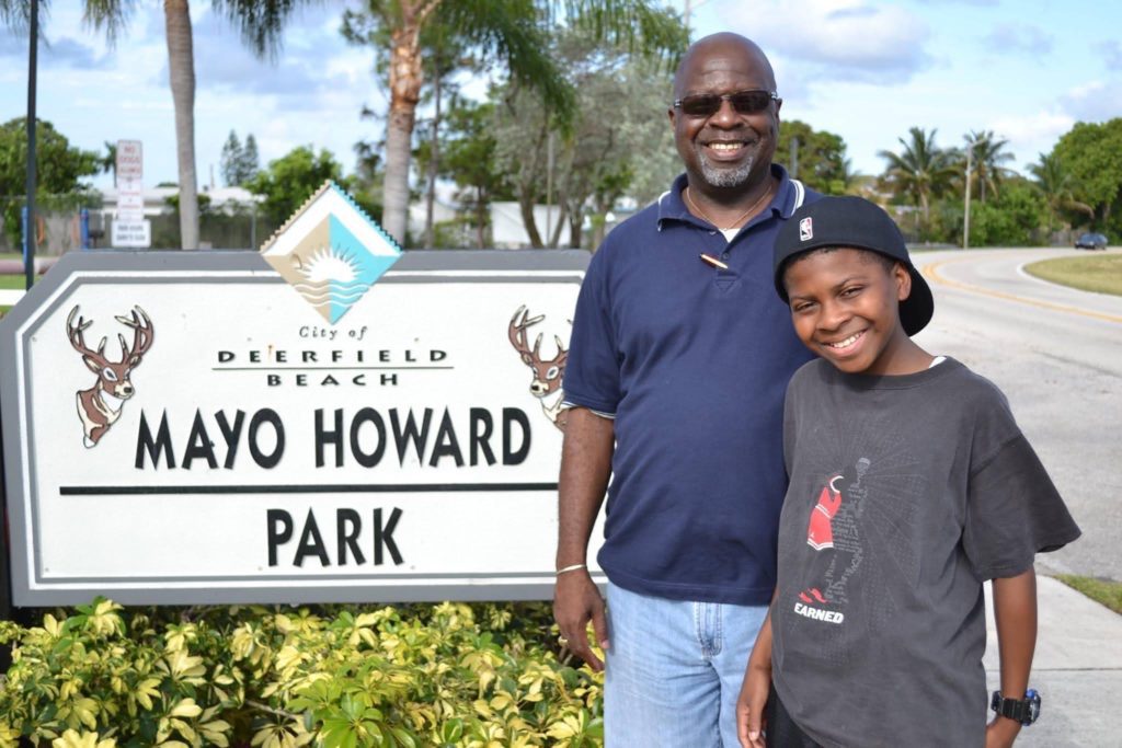 A father and son having their photo in front of Mayo Howard Park signage